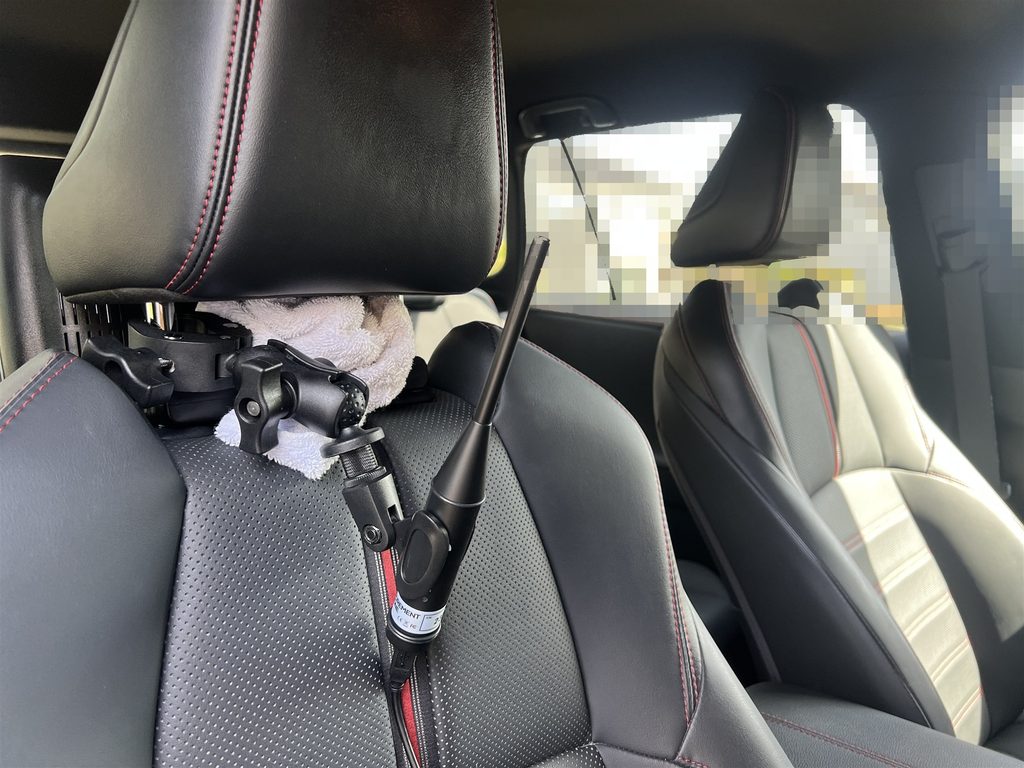 運転席のヘッドレストのパイプにクランプで固定し、天井向きにセットした測定用マイク